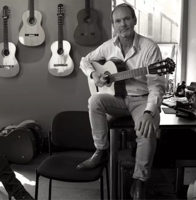 man in his office with guitars on the wall